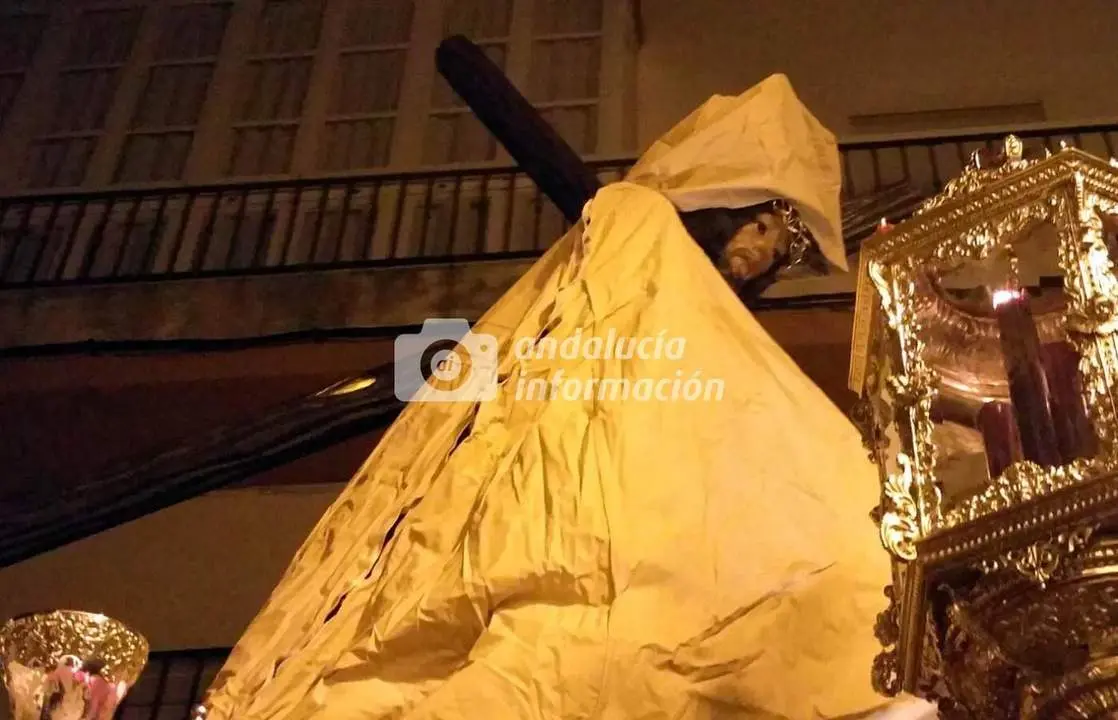 El Nazareno cubierto por el capote de lluvia.