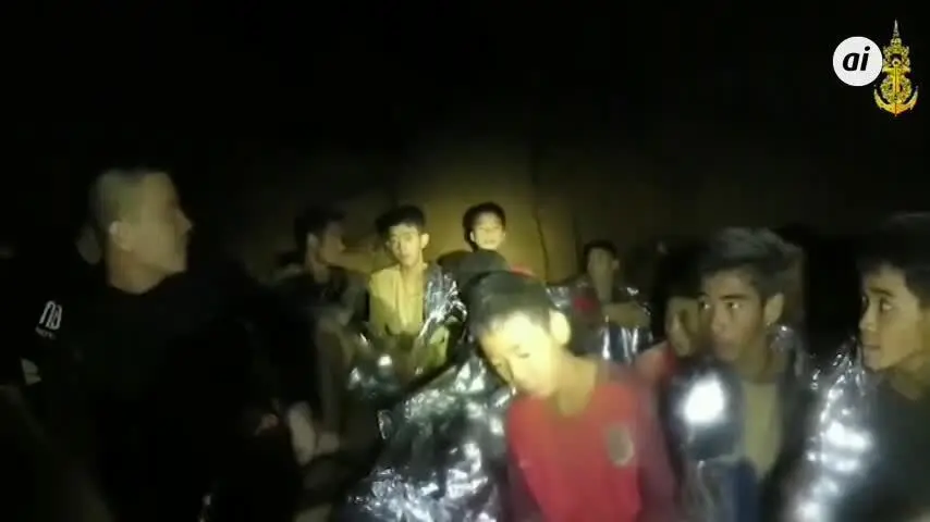 Varios soldados acompa&ntilde;an a los ni&ntilde;os atrapados en la cueva tailandesa