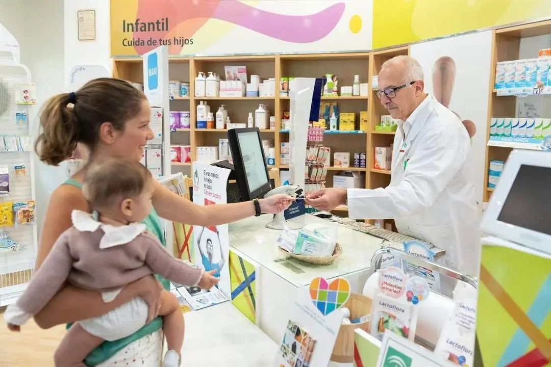 Una mujer presenta su receta electr&oacute;nica en una farmacia. - EP