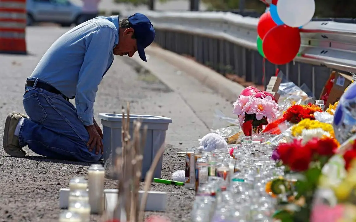 Un hombre se arrodilla ante la zona del tiroteo. - EFE