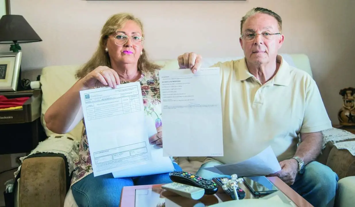 Esmeralda junto a su marido, muestra los documentos de su convalecencia - Rafael Dom&iacute;nguez