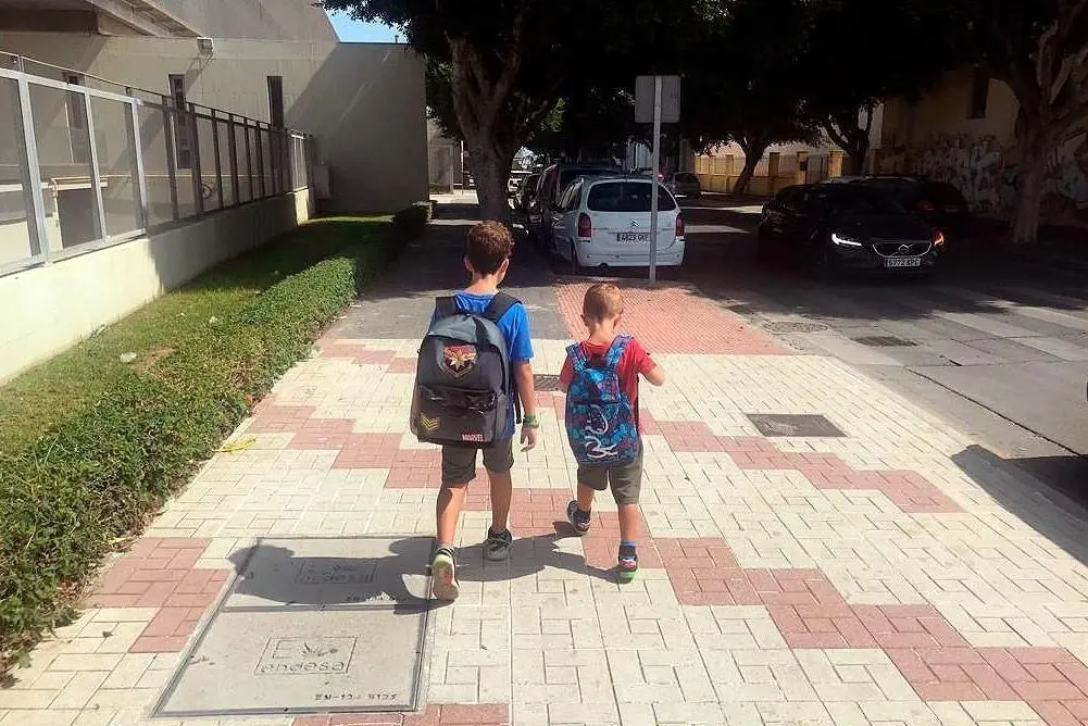 Ni&ntilde;os caminando con una mochila. - uma