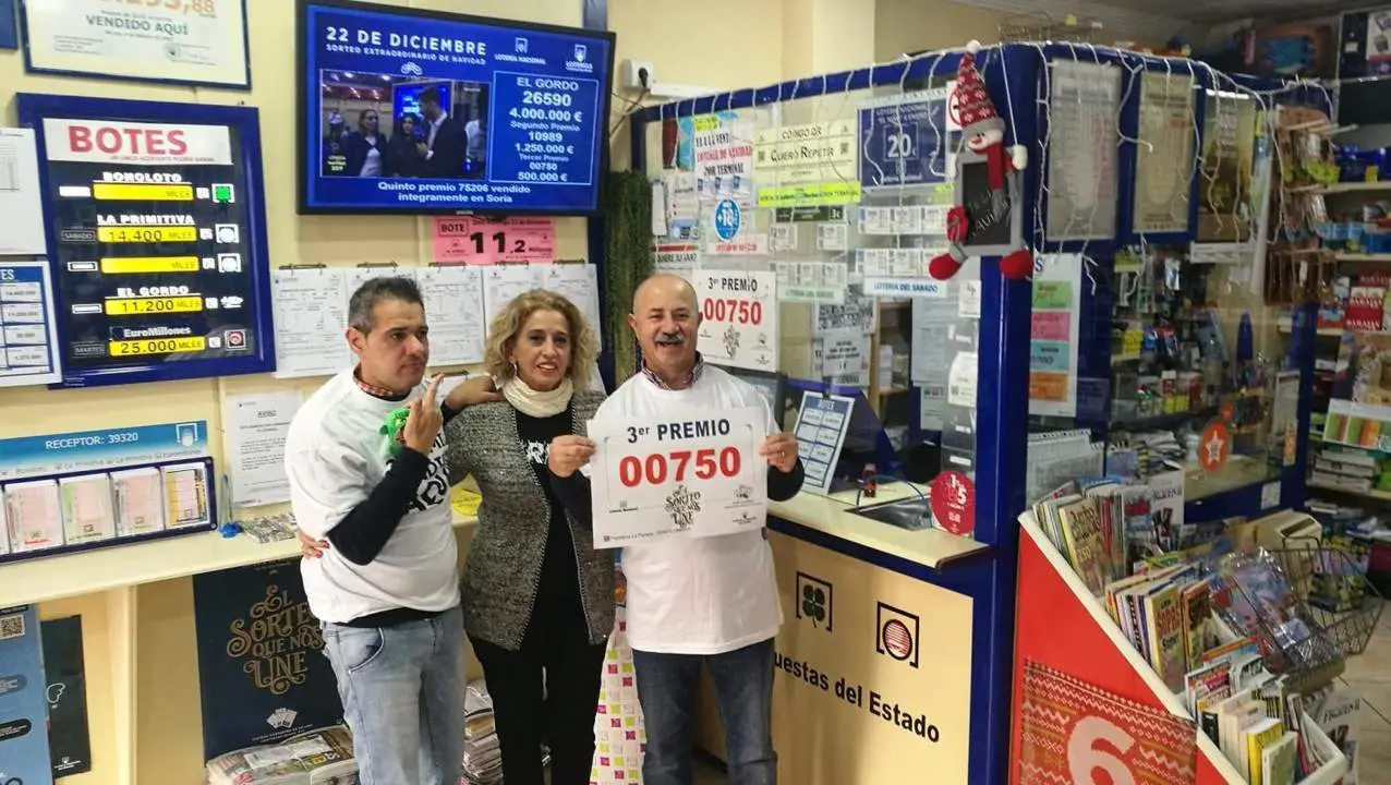 Juan Gonz&aacute;lez, junto a su mujer y su hijo en la librer&iacute;a 'La Parada' de Punta Umbr&iacute;a. - VH