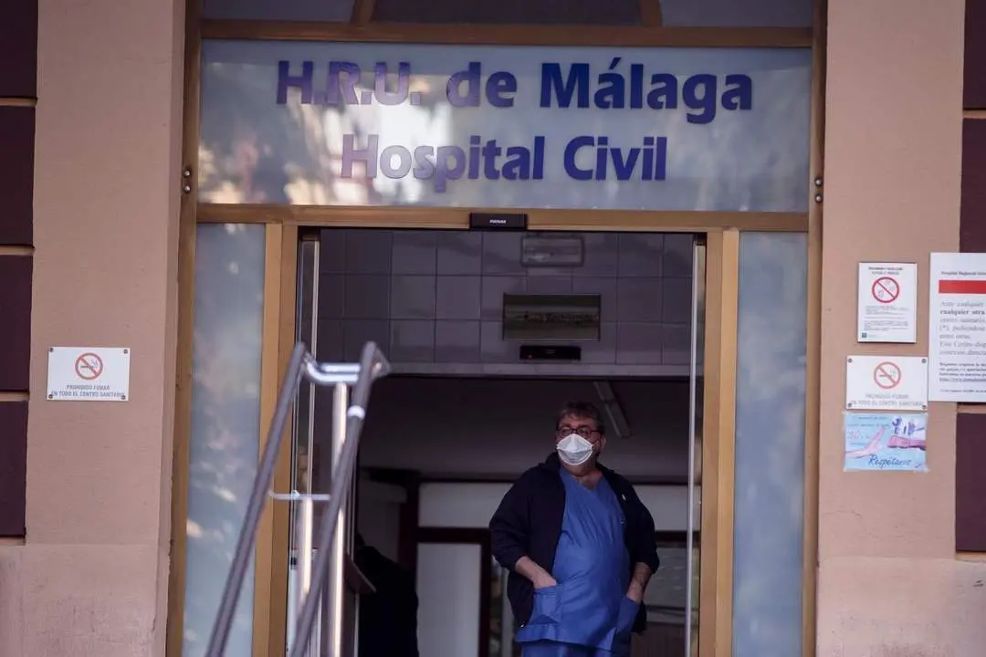 Un trabajador del Hospital Civil de M&aacute;laga porta una mascarilla protectora en la entrada de urgencias. - efe