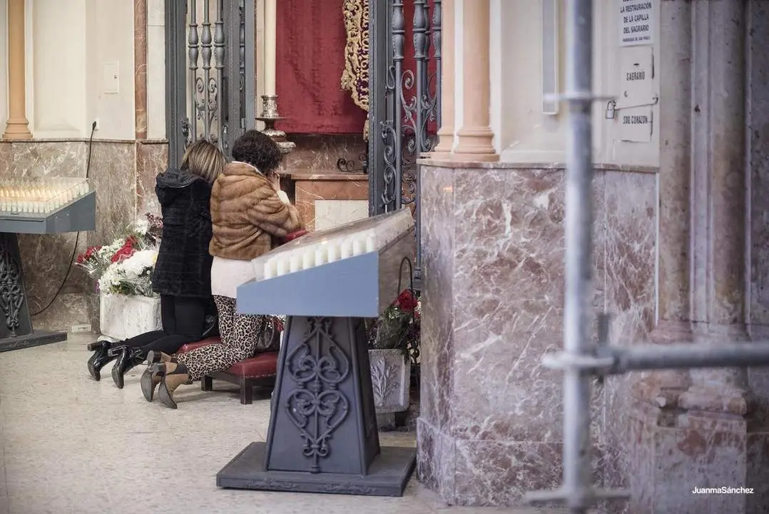 Dos fieles oran en la parroquia de San Pablo de M&aacute;laga capital. - JUANMA S&Aacute;NCHEZ/COFRAD&Iacute;A DEL CAUTIVO Y LA TRINIDAD