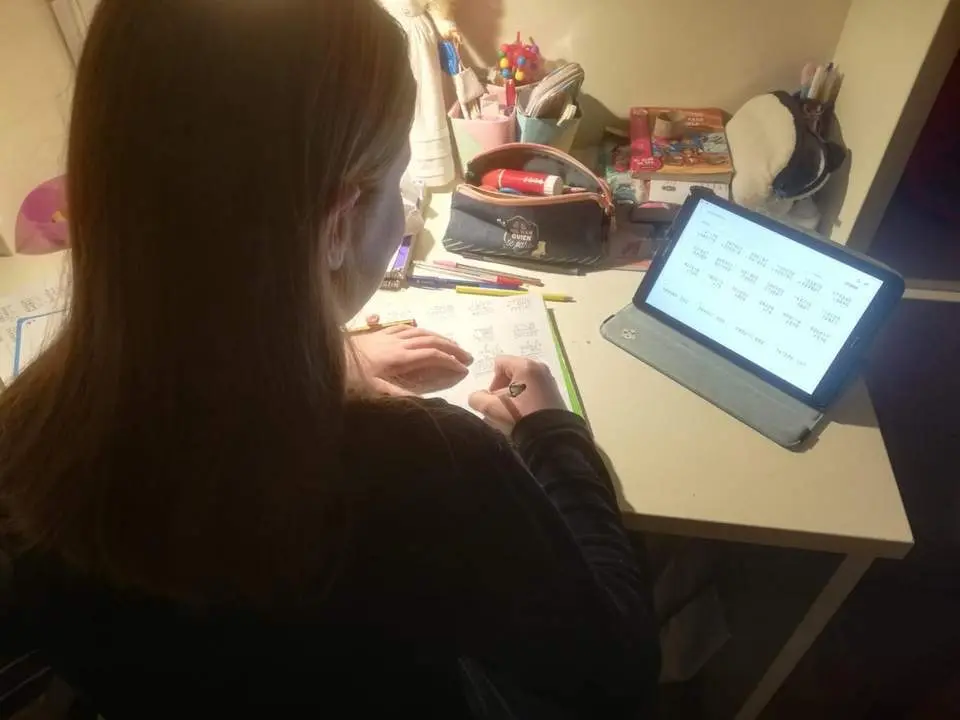 Una estudiantes en su casa haciendo sus tareas diarias.  - VS