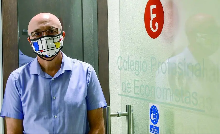 Javier Cabeza de Vaca Gonz&aacute;lez, con mascarilla, a la entrada de la sede del Colegio de Economistas. - Eulogio Garc&iacute;a