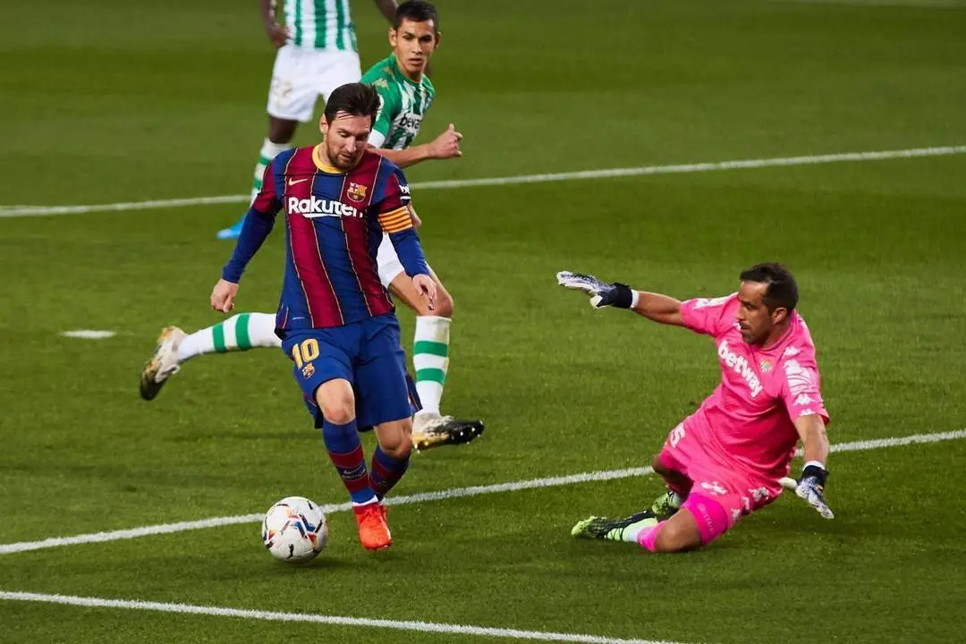 Los futbolistas del Real Betis, Claudio Bravo y Aissa Mandi, intentan tapar un disparo de Messi. - efe
