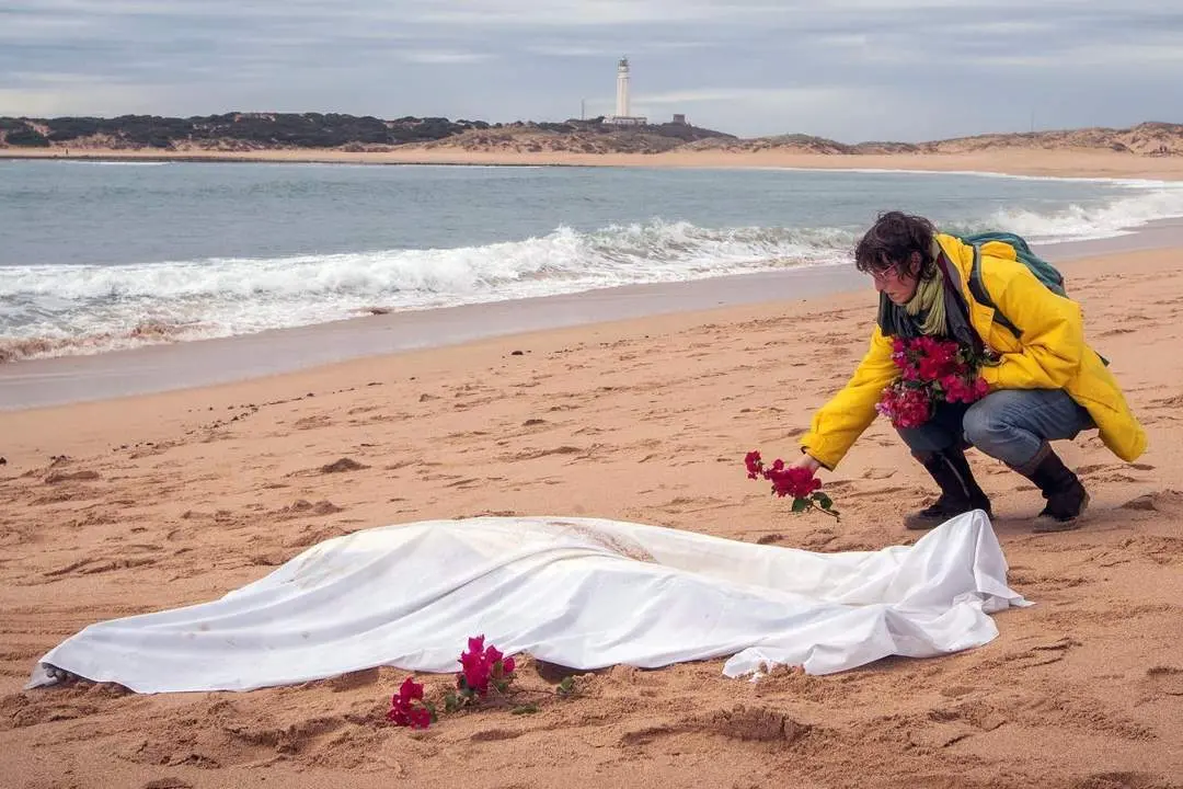 Una mujer coloca unas flores alrededor de otro de los cad&aacute;veres. - EFE/ Rom&aacute;n R&iacute;os