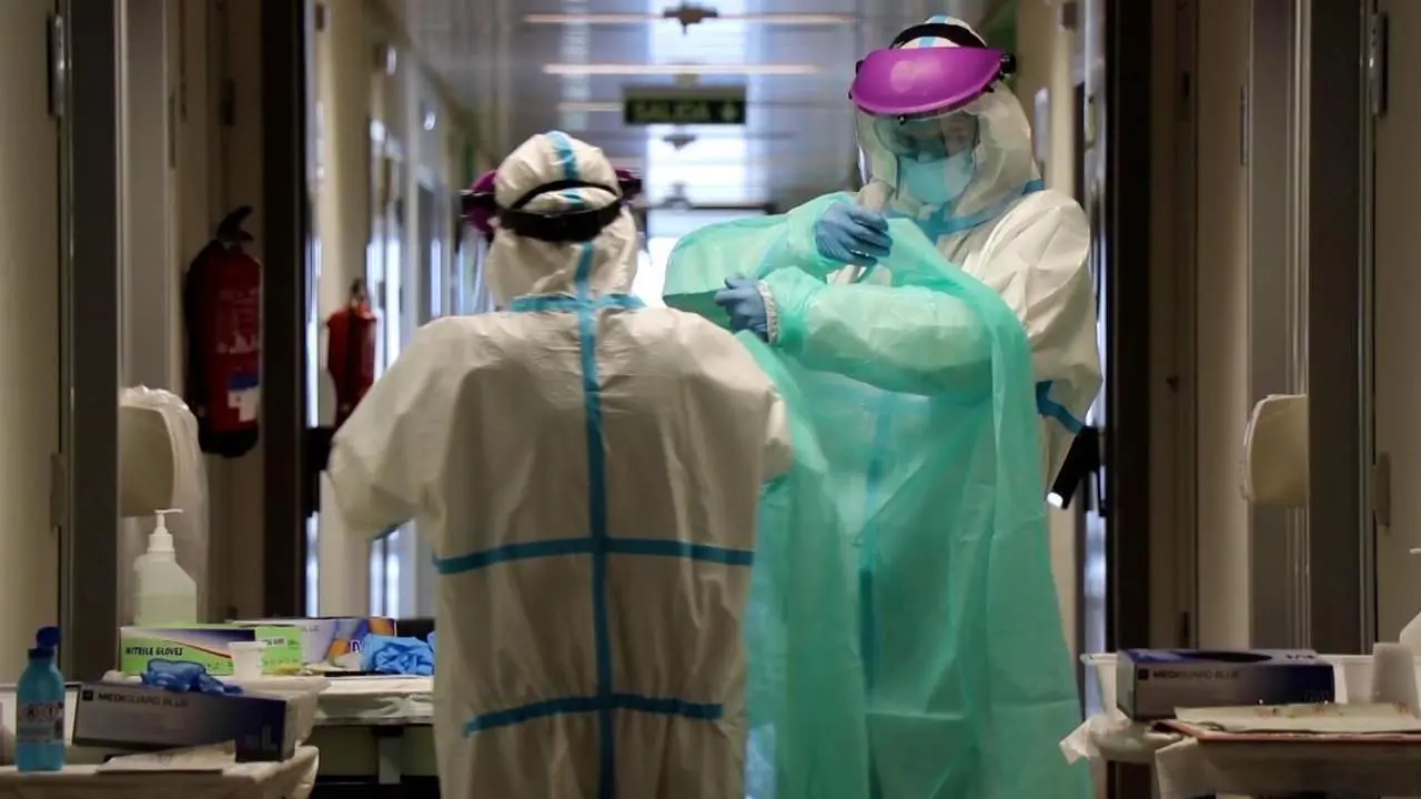 Dos m&eacute;dicos se cubren con material de protecci&oacute;n para prevenir el coronavirus. - E. P.