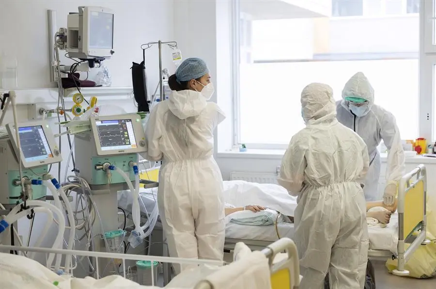 Profesionales sanitarios vestidos con EPIs atienden a un enfermo. - EFE