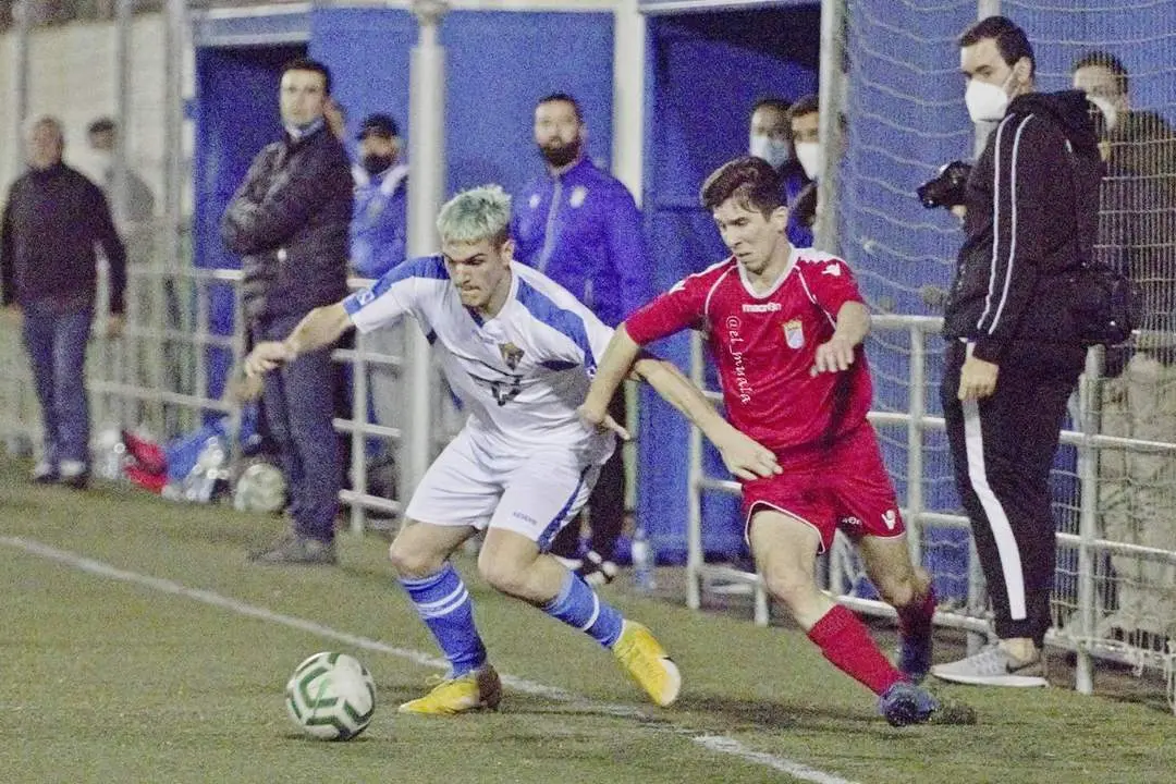 Cristian controla el bal&oacute;n cerca de los dos banquillos ante la presi&oacute;n de un jugador visitante - Muala