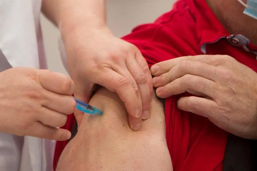 Una trabajadora sanitaria vacuna a un hombre contra el coronavirus. - EFE