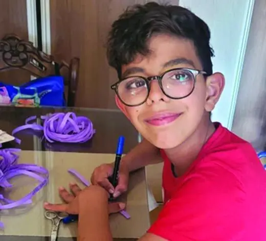 Hugo preparando pulseras solidarias para recaudar fondos para su causa. - Todos somos Hugo
