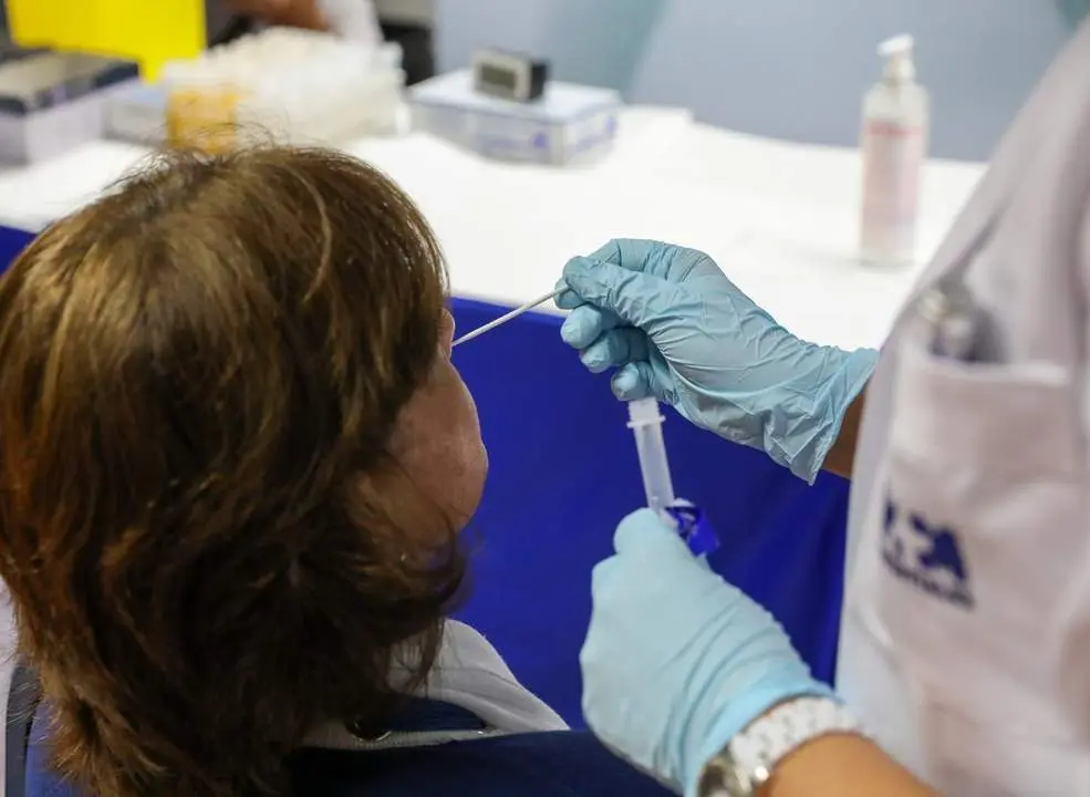 Un sanitario realiza un test de ant&iacute;genos a una mujer. - EP
