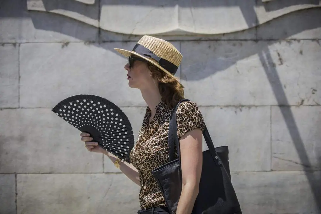 Una mujer se abanica mientras pasea por la calle. - Europa Press