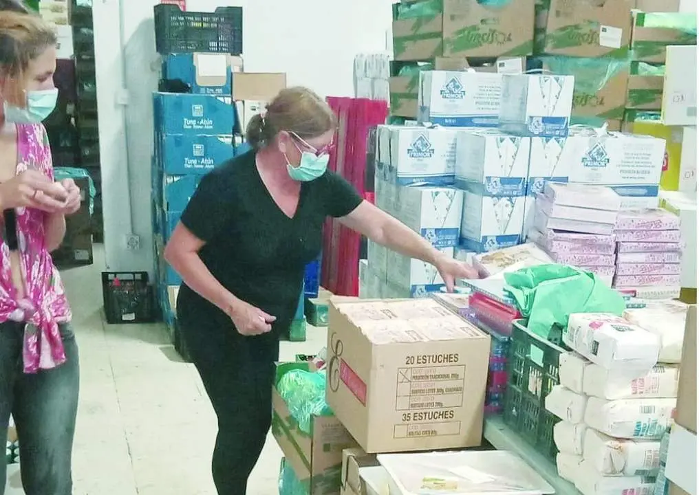 Dos voluntarias ayudan a organizar la comida de la Asociaci&oacute;n Lagunillas, en la capital malague&ntilde;a, que cada d&iacute;a da de comer a m&aacute;s gente. - Cedida