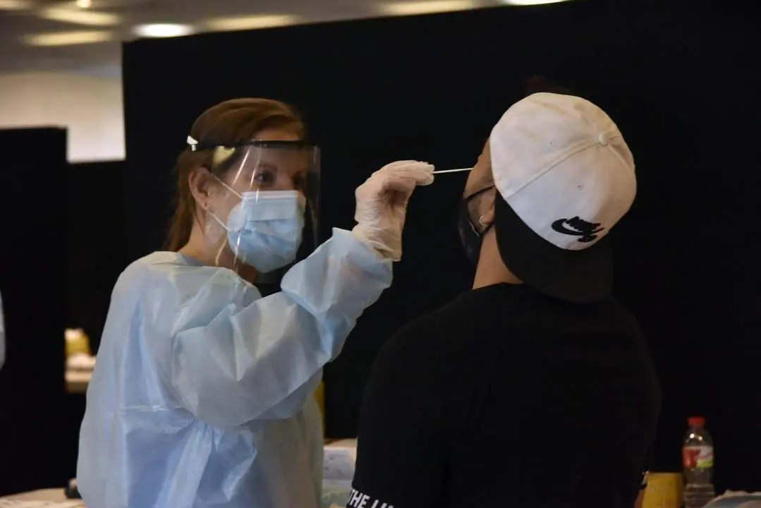 Una trabajadora sanitaria realiza un test de ant&iacute;genos a un joven. - David Oller - Europa Press