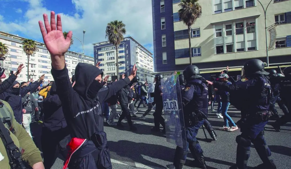 Manifestantes frente a los agentes antidisturbios de la Polic&iacute;a Nacional en C&aacute;diz - EFE