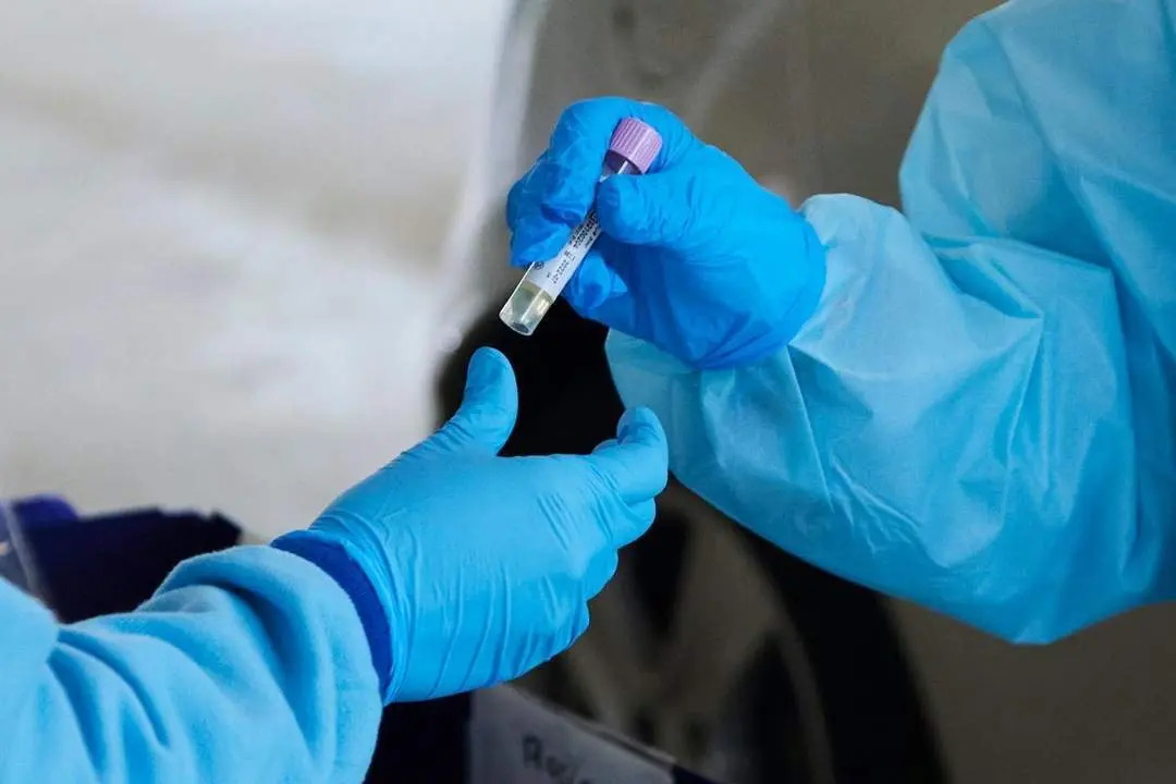 Dos sanitarias recogen una PCR. - Archivo