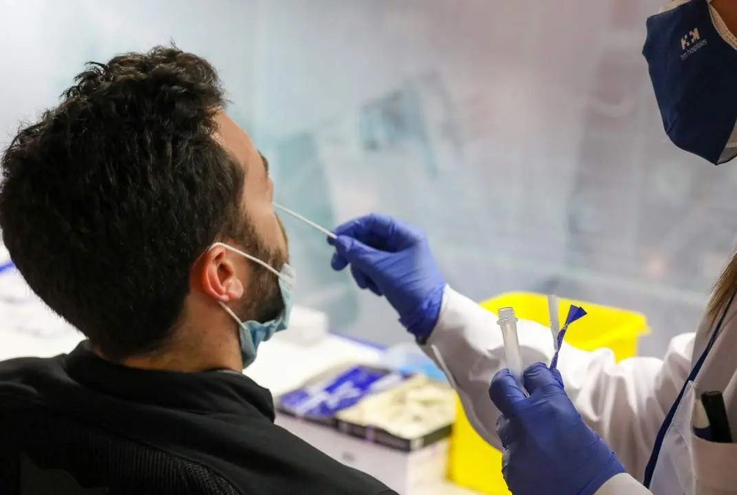 Un sanitario realiza un test de ant&iacute;genos a un hombre. - EP