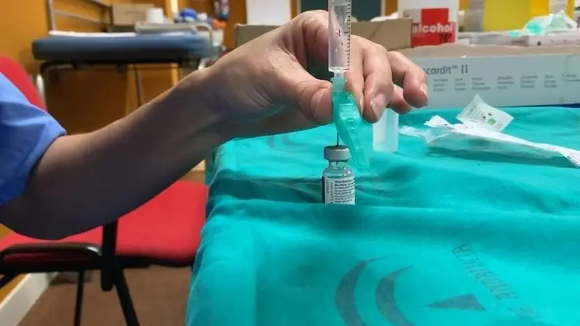 Un profesional sanitario con una vacuna. - JUNTA DE ANDALUC&Iacute;A