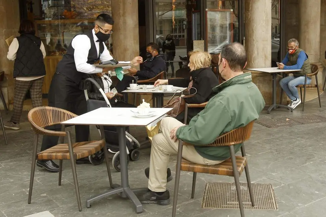 Un camarero atiende a varios clientes en la terraza de un bar en Palma, Mallorca - EP