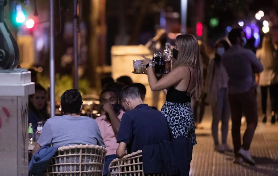 Una camarera atiende a varias personas. | Europa Press.