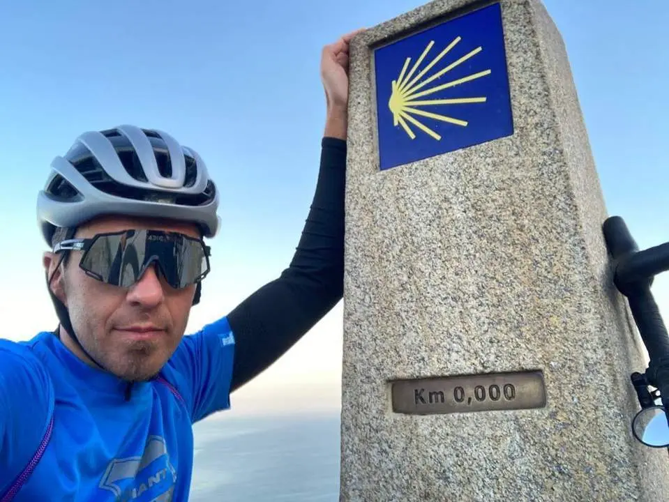 Carlos Molina posa junto al poste de piedra que marca el kil&oacute;metro 0. - Viva. 