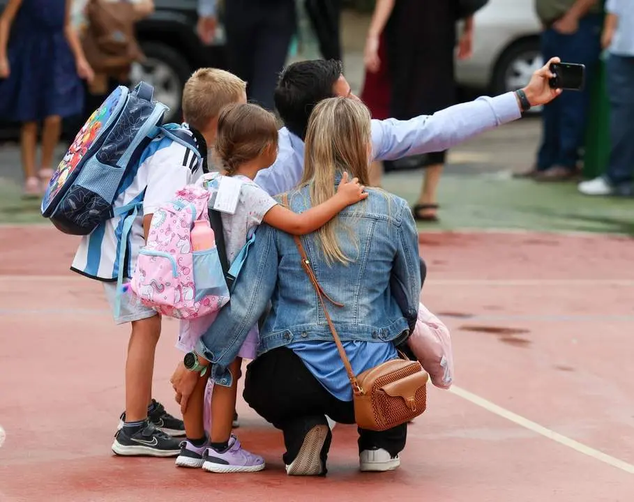 Varios ni&ntilde;os con una mujer en un patio del colegio.  - EP