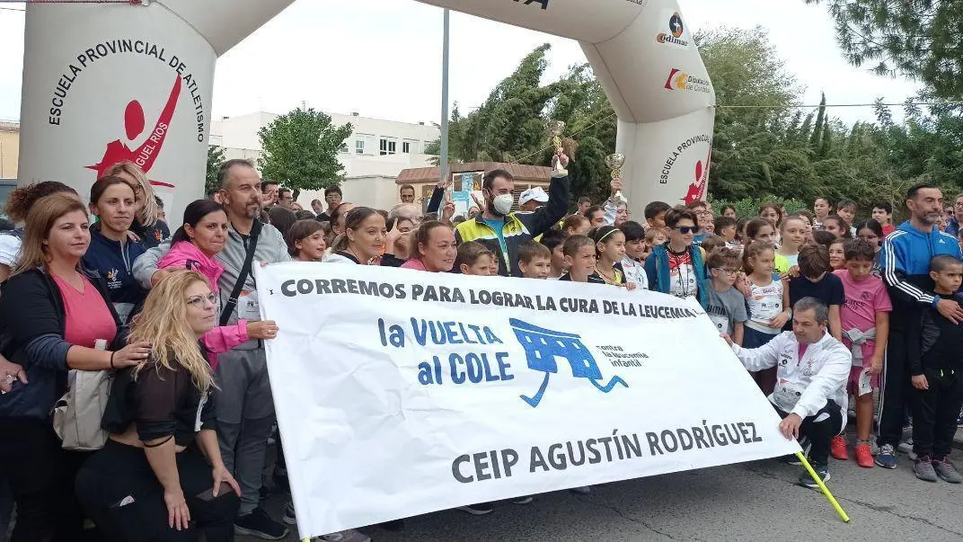 Familias de los escolares portando la pancarta conmemorativa. - 