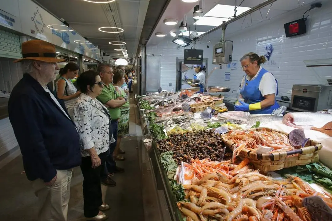 Varias personas compran alimentos en un mercado. - Europa Press