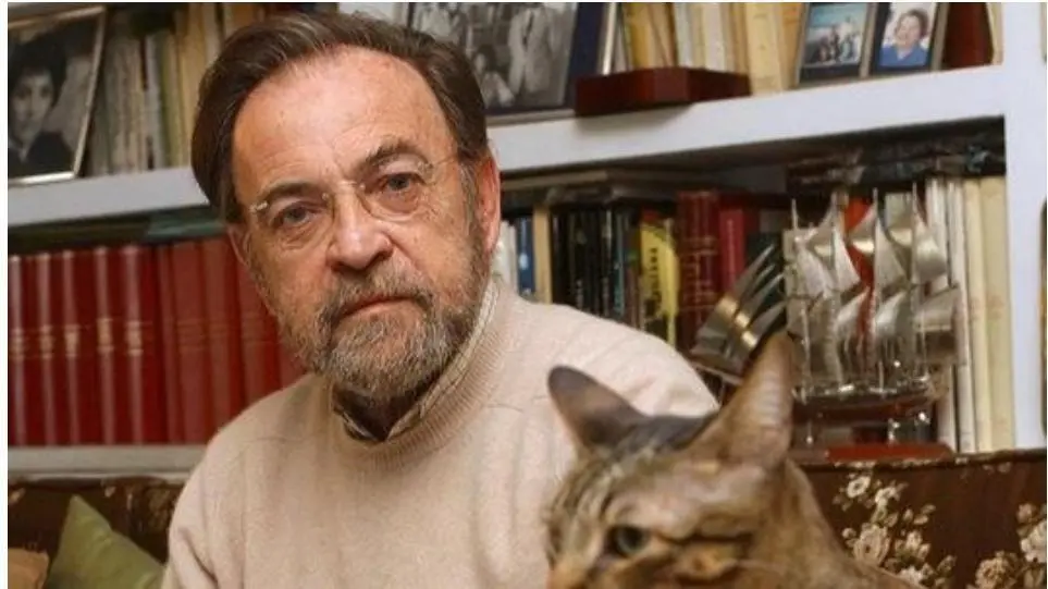 Antonio Burgos, junto con uno de sus gatos, delante de su biblioteca. - MJF
