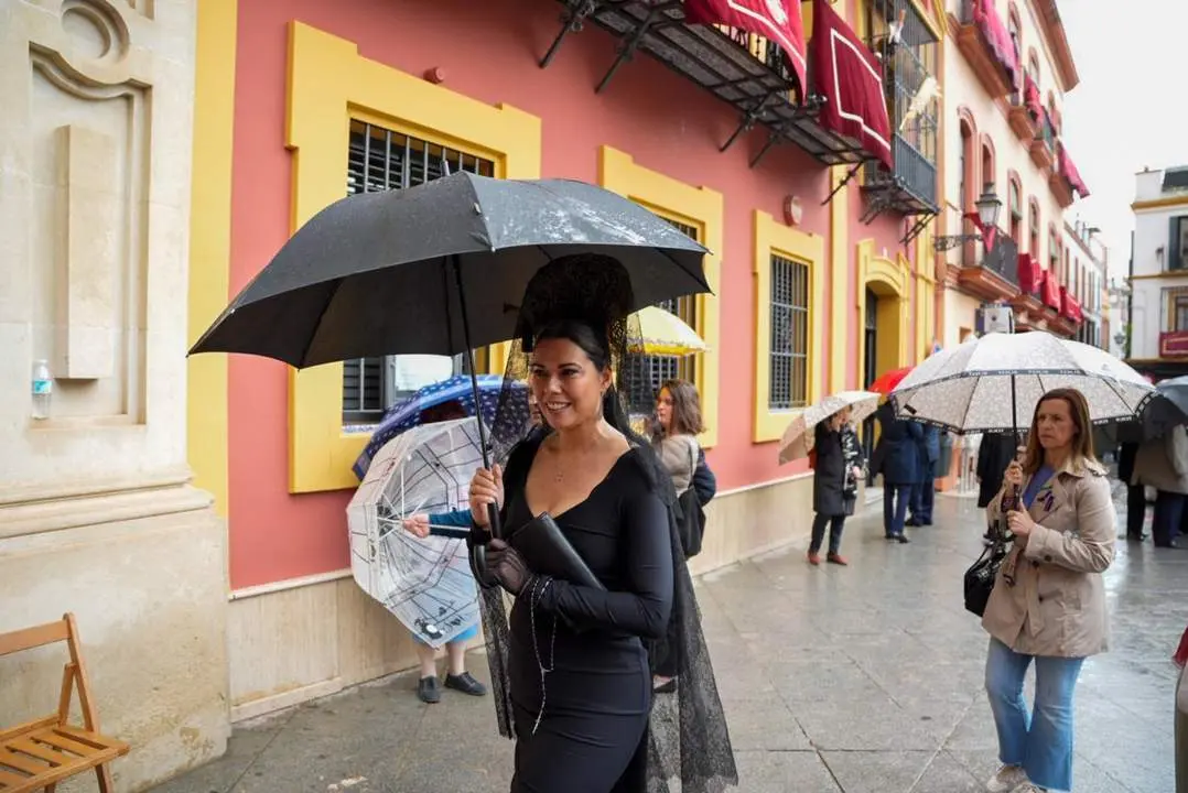 Vestida de mantilla bajo el paraguas. - Europa Press