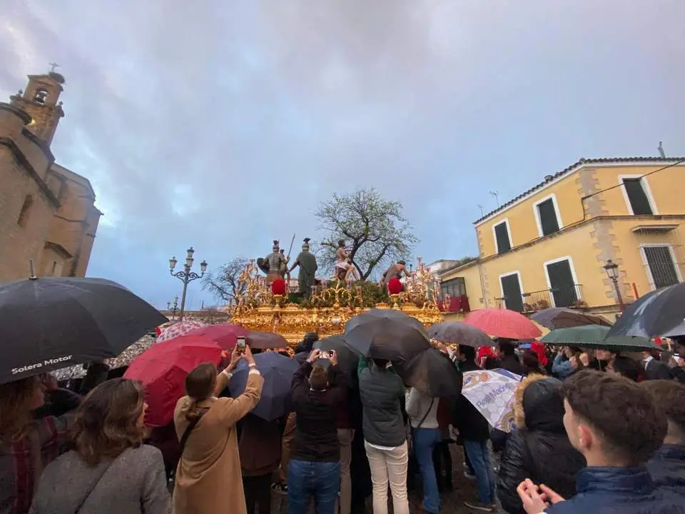 El p&uacute;blico se resguarda con paraguas de la lluvia en una procesi&oacute;n.  - Marga &Aacute;vila