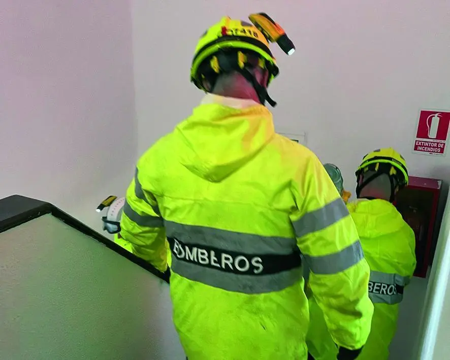 Los bomberos en el interior de uno de los bloques al filtrarse agua. - Viva