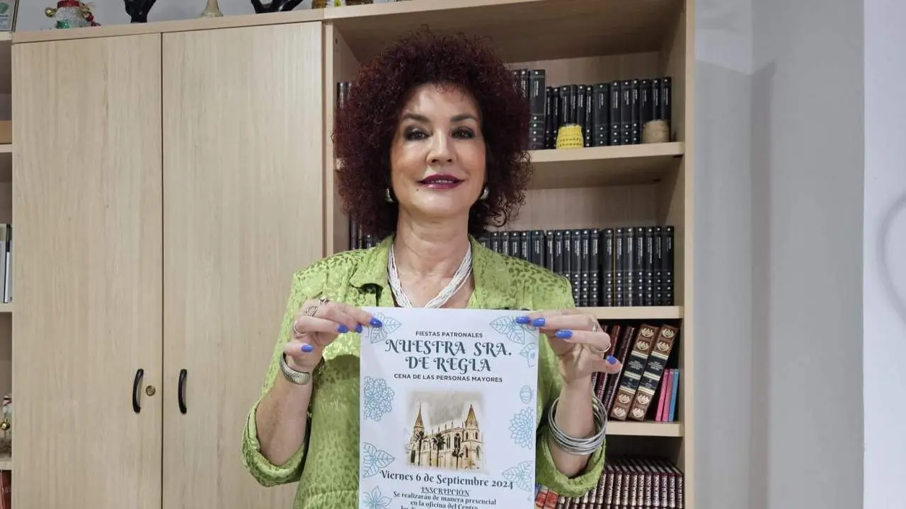 Isabel Mar&iacute;a Fern&aacute;ndez sostiene el cartel anunciador de la cena - Viva Chipiona