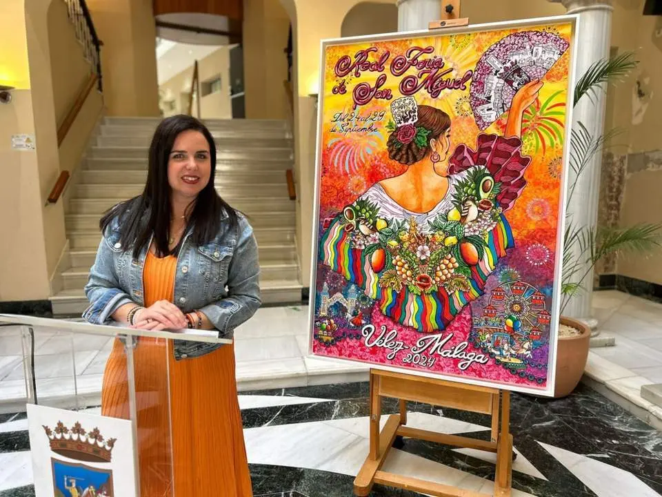 Lourdes Pi&ntilde;a con el cartel de la Feria. - Ayto. V&eacute;lez-M&aacute;laga