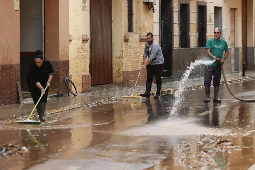 Voluntarios y vecinos de Paiporta limpian una de las calles. - EFE/Biel Ali&ntilde;o