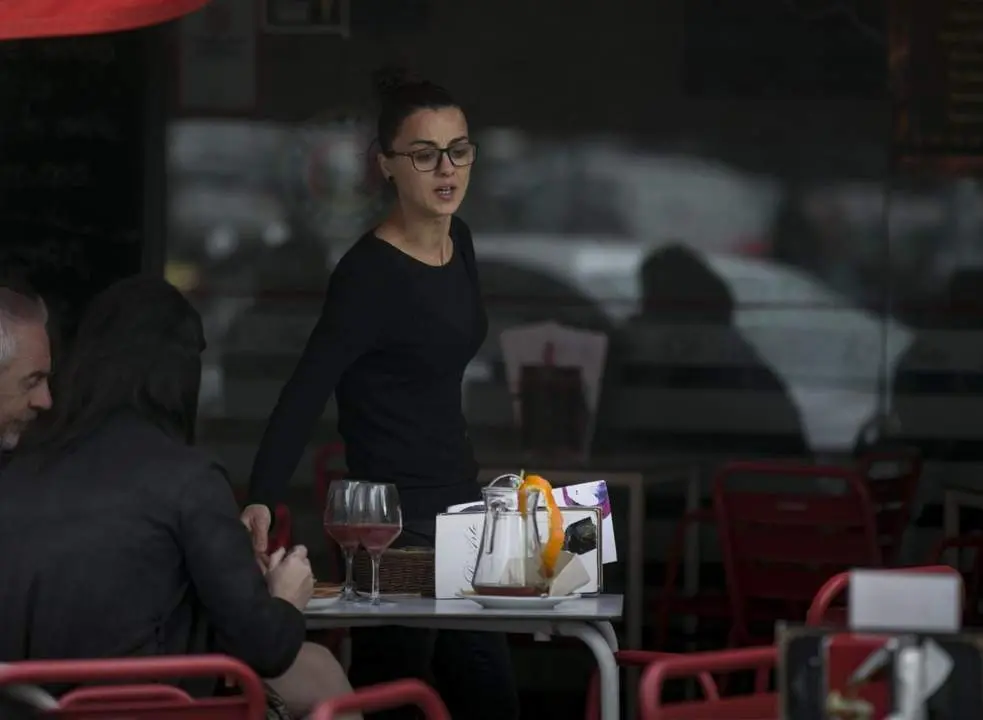 Una camarera atiende una mesa. | Europa Press