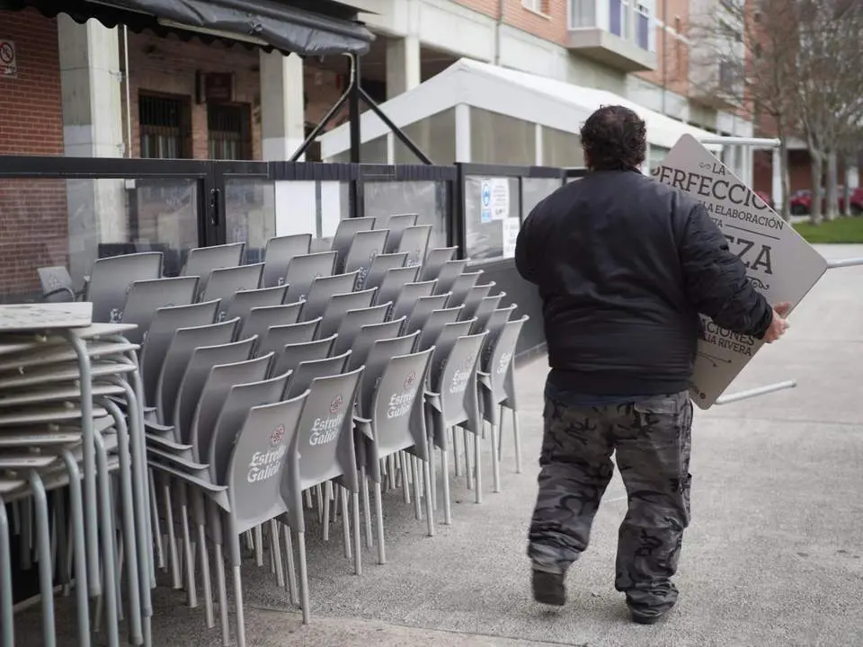 Un camarero coloca sillas. - Europa Press