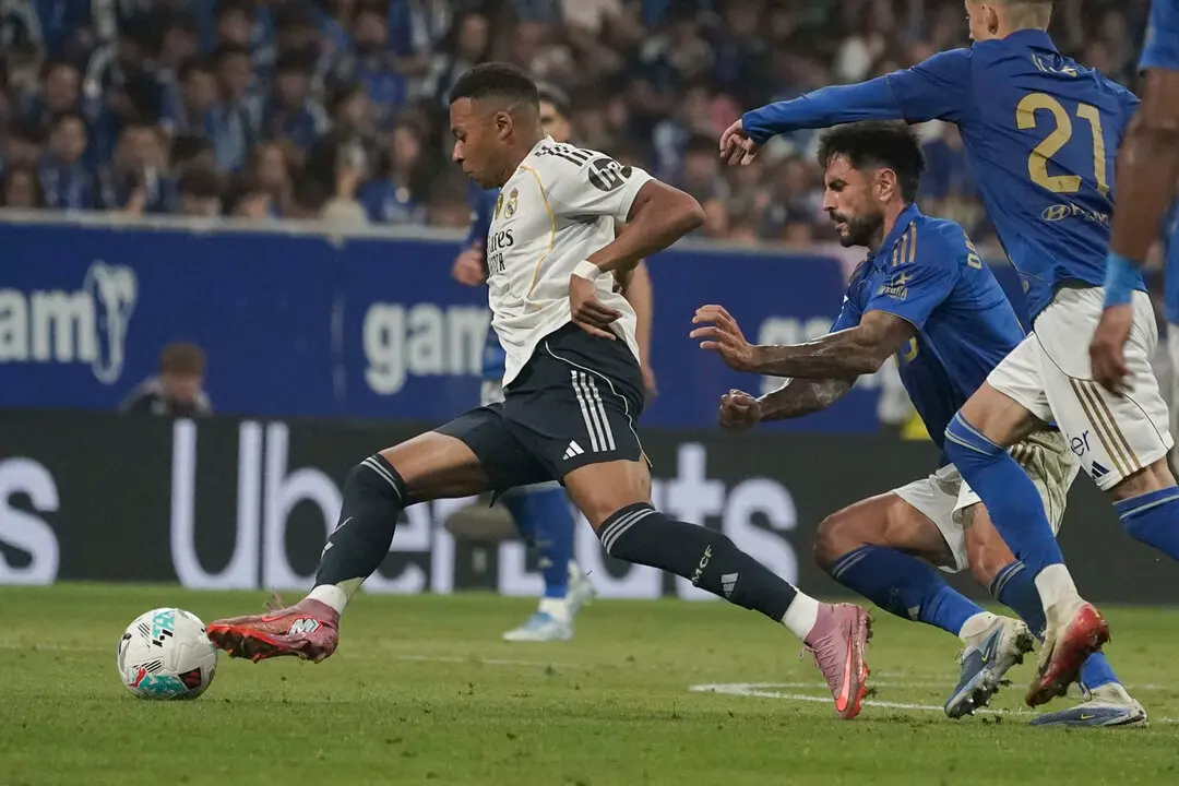 El delantero franc&eacute;s del Real Madrid Kylian Mbapp&eacute; escapa de dos jugadores del Oviedo | Paco Paredes / EFE