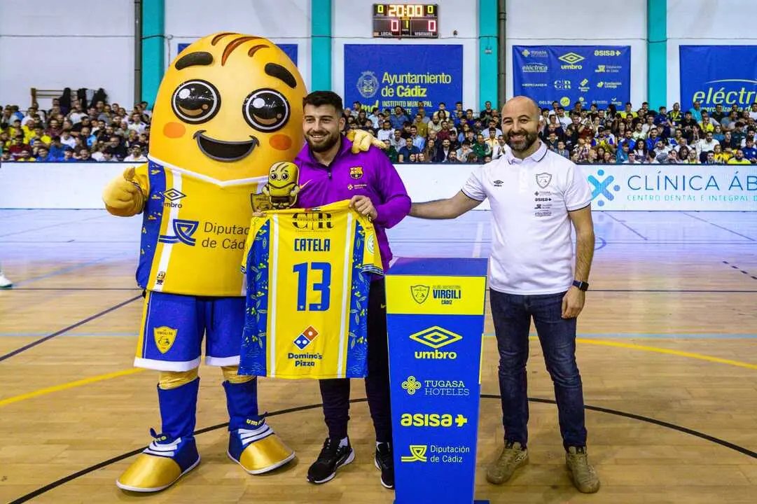 Juanjo Catela, junto a Jos&eacute; Luis Botana y la mascota del Virgili recogiendo el Panader&iacute;n de Honor. | CD Virgili.