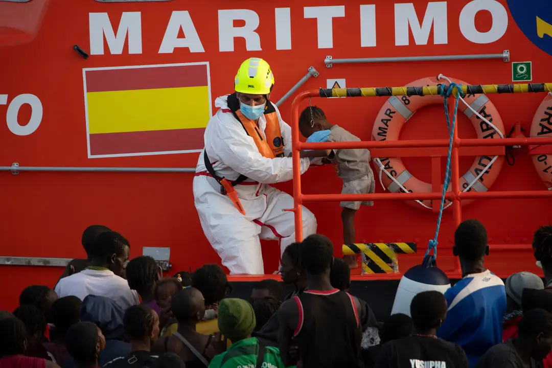  Una persona de Salvamento Mar&iacute;timo ayuda a un menor. | EP 