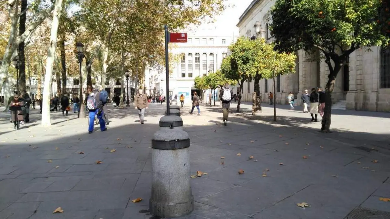 Una persona circula en patinete por el and&eacute;n del Ayuntamiento de Sevilla. - MLV