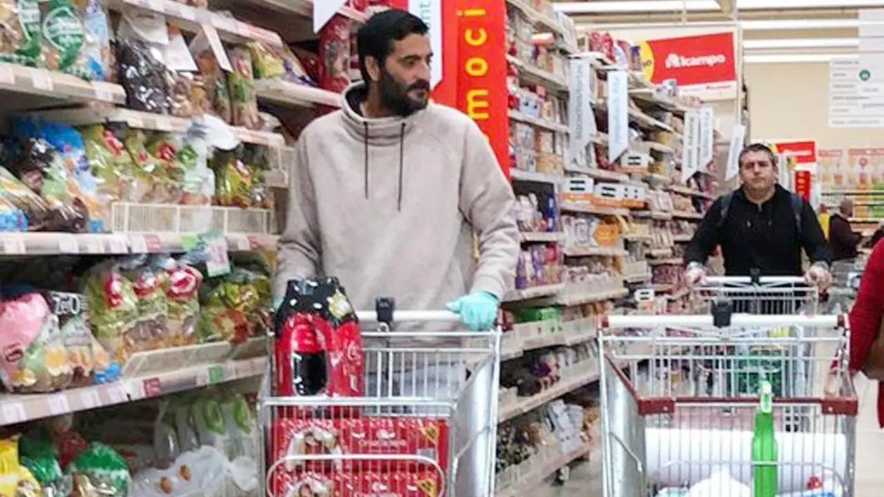El jerezano G&uuml;iza, delantero del Atl&eacute;tico Sanluque&ntilde;o, comprando productos l&iacute;quidos en un supermercado - A. I.
