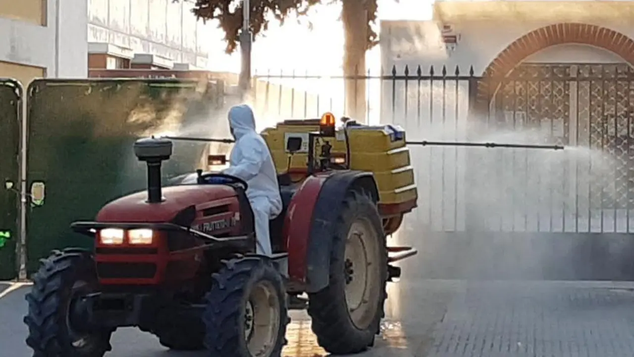 Un tractorista desinfectando en la Plaza Central, entre el CEIP Maestra Caridad Ruiz y la Farmacia - Guancho Ib&aacute;&ntilde;ez
