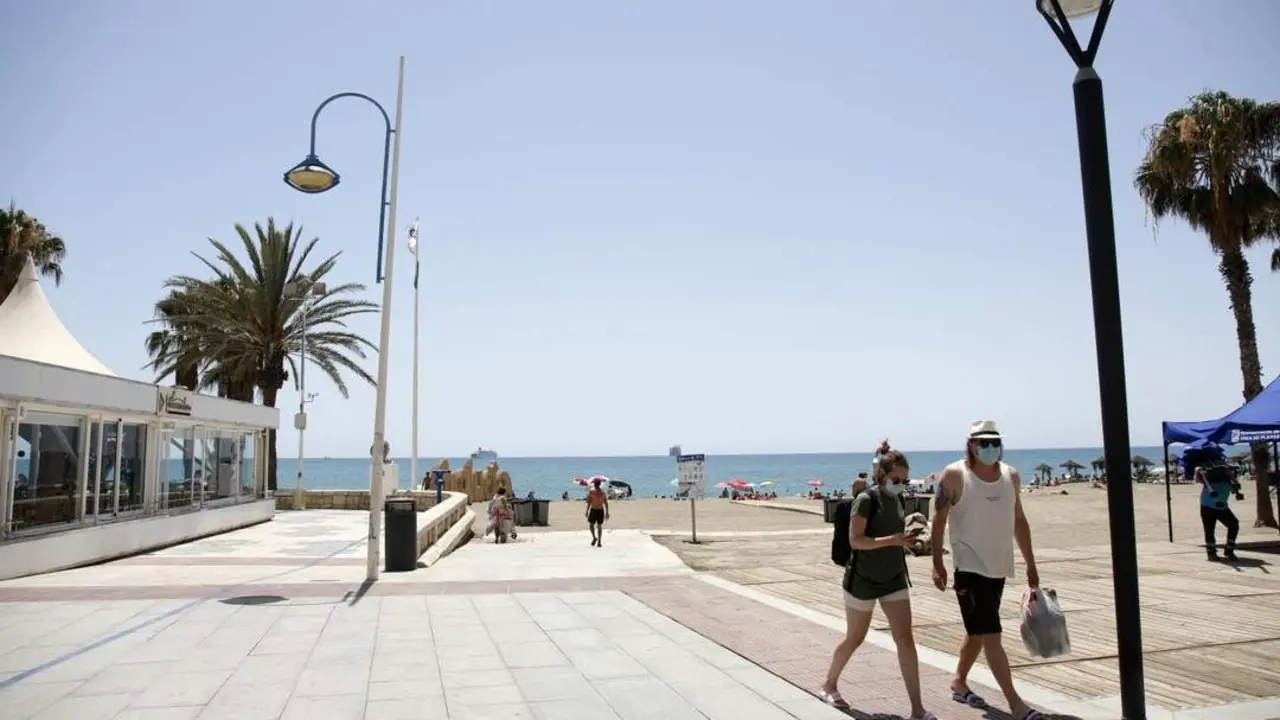 Dos personas pasean con mascarillas en la playa de La Malagueta. - &Aacute;lex Zea / EP