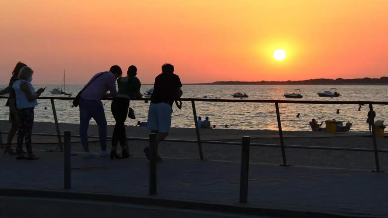 Varios visitantes contemplando el atardecer en el Paseo Mar&iacute;timo con Do&ntilde;ana al fondo - Ra&uacute;l J. Bustillos