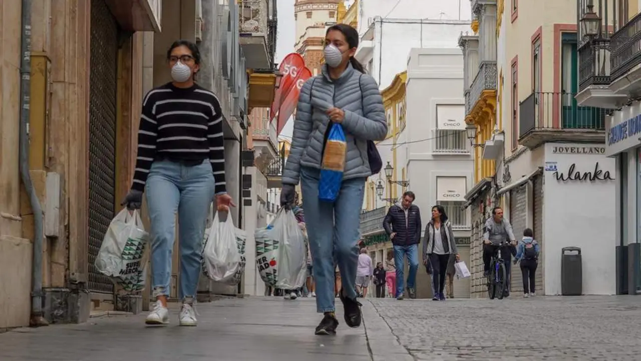 Dos personas con mascarillas por la calle Tetu&aacute;n de Sevilla. - ep